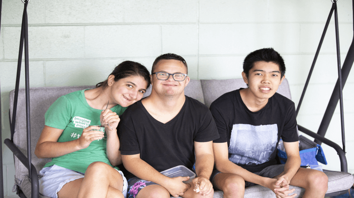 Group of smiling friends on a swinging chair