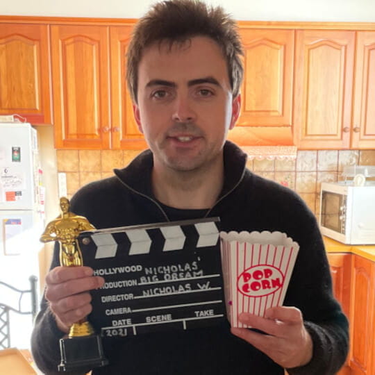 Nicholas holding popcorn, Oscar statue and Hollywood movie take card