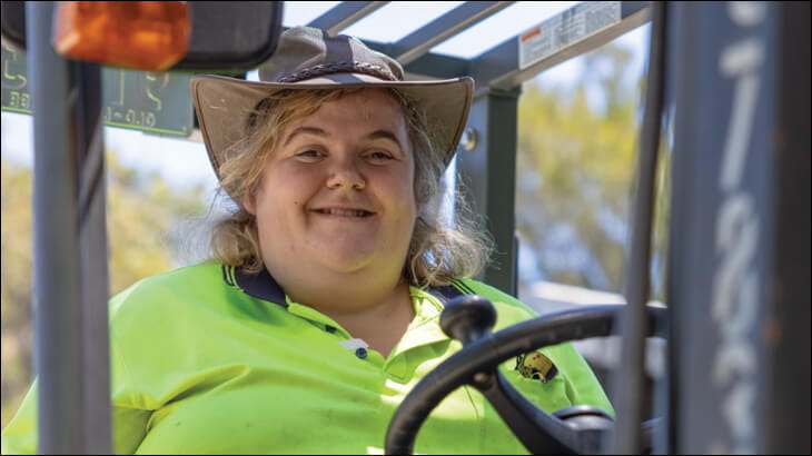 Smiling woman driving a tractor