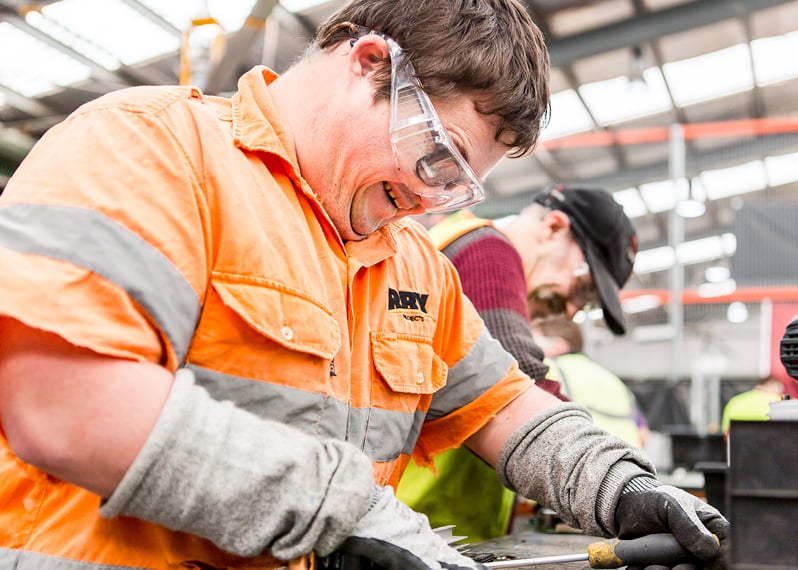 man-wearing-protective-glasses-smiling-while-working