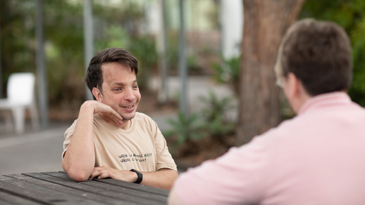 Two-people-seated-outside-talkingjpeg