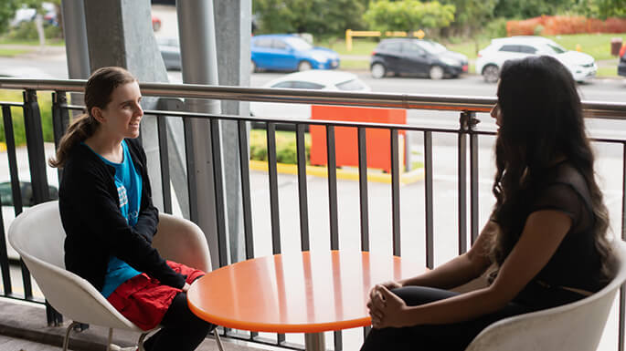 Two-women-seated-outside-talkingjpeg