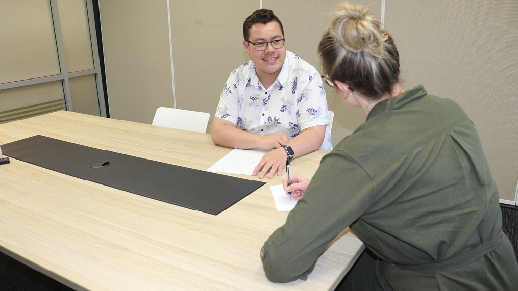 two-people-meeting-across-conference-table.jpg