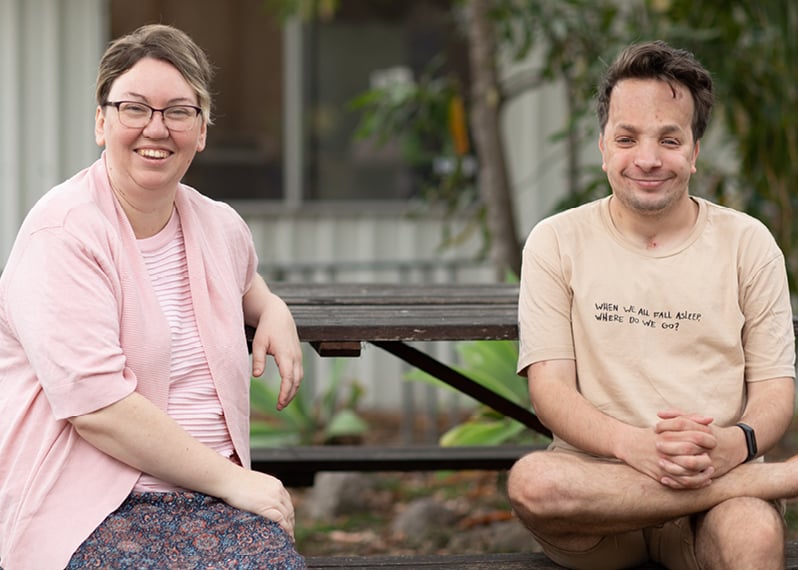 two-people-smiling-while-sitting-on-a-bench