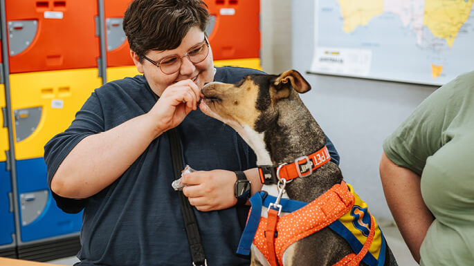 woman-smiling-while-feeding-a-dog-a-treat.jpeg