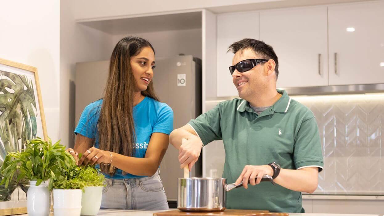 women-supporting-man-in-kitchen